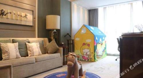 a dog sitting in a living room with a dog house at Xian Jue Vu Hotel in Xi'an