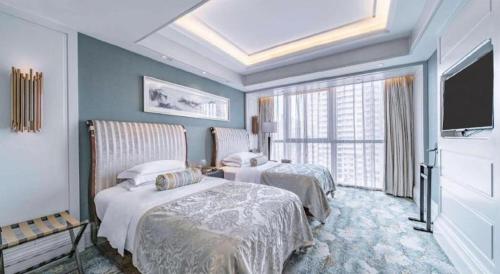 a hotel room with two beds and a flat screen tv at Xian Jue Vu Hotel in Xi'an