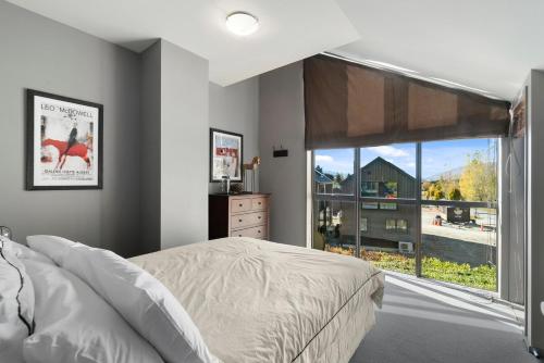 a bedroom with a bed and a large window at Cardrona Sanctuary in Cardrona