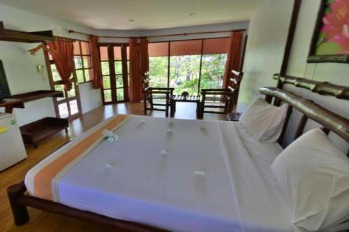 ein Schlafzimmer mit einem großen weißen Bett in einem Zimmer in der Unterkunft Alongkot Beach Resort Khanom in Ban Phang Phrao