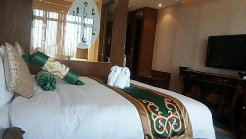 a bedroom with a large bed with a clock on the wall at Hohhot Inner Mongolia Hotel in Hohhot