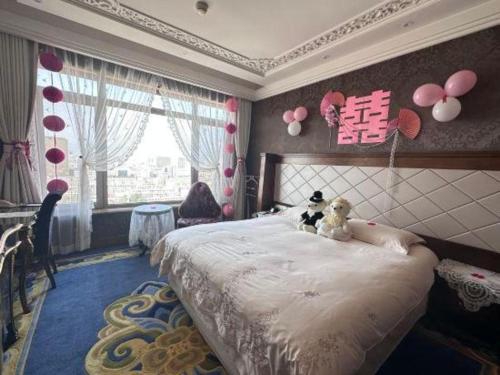 a bedroom with a bed with two teddy bears on it at Hohhot Inner Mongolia Hotel in Hohhot