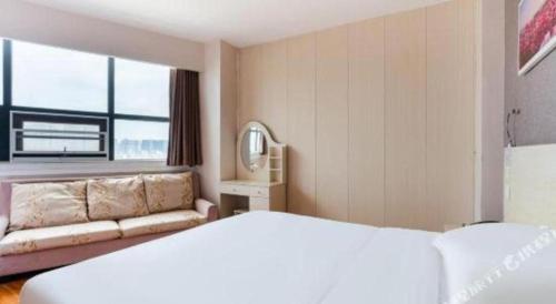 a hotel room with a bed and a couch at 7 Days Inn Chengdu Huayang Metro Station Binfen Plaza in Chengdu