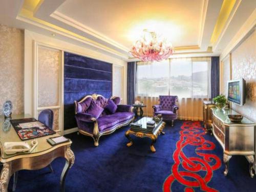 a living room with purple furniture and a large red carpet at Hohhot Inner Mongolia Hotel in Hohhot