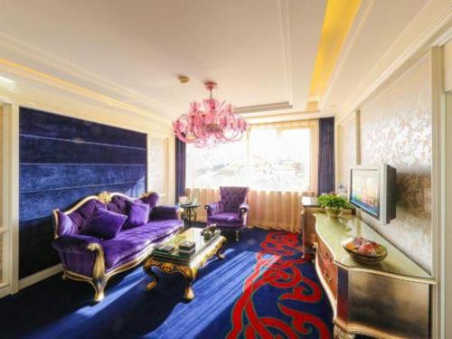 a living room with a purple couch and a chandelier at Hohhot Inner Mongolia Hotel in Hohhot