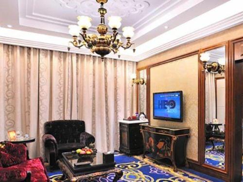 a living room with a chandelier and a television at Hohhot Inner Mongolia Hotel in Hohhot