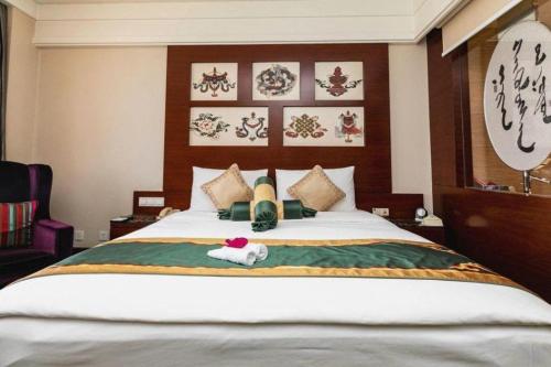 a bedroom with a bed with two towels on it at Hohhot Inner Mongolia Hotel in Hohhot