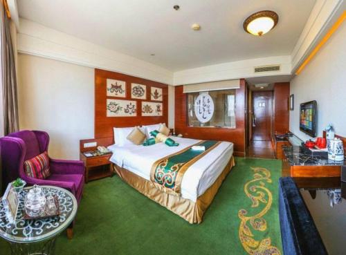 a hotel room with a bed and a chair at Hohhot Inner Mongolia Hotel in Hohhot