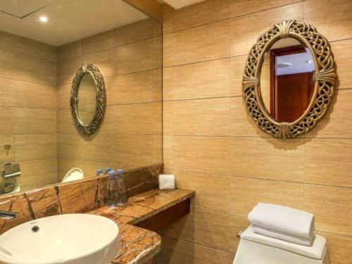 a bathroom with a sink and a toilet and a mirror at Hohhot Inner Mongolia Hotel in Hohhot