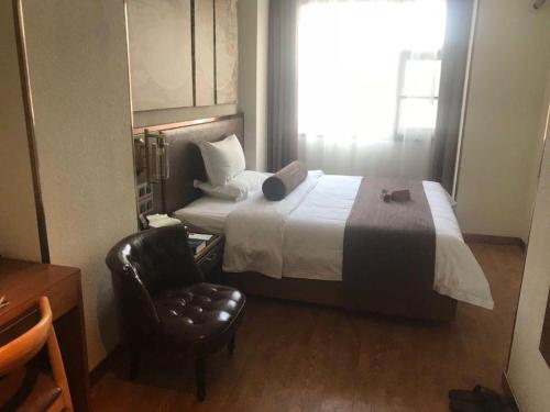 a hotel room with a bed and a chair at James Joyce Coffetel Xi'an Lingtong The Terracotta Army Huaqingchi University Town Metro Station in Xi'an