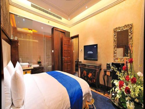 a hotel room with a bed and a bathroom at Hohhot Inner Mongolia Hotel in Hohhot