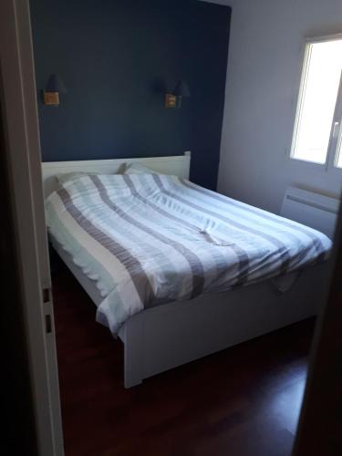 Ce lit se trouve dans une chambre dotée d'un mur bleu. dans l'établissement Superbe maison avec Spa en direct, au Haillan