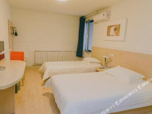 a hospital room with two beds and a sink at Jinjiang Inn Qingdao Development Zone Jinggangshan Rd. in Huangdao