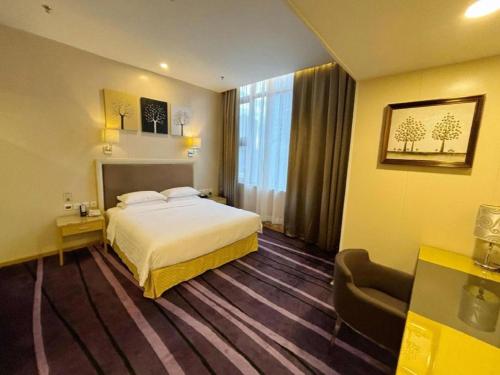 a hotel room with a bed and a chair at The Bauhinia in Shenzhen