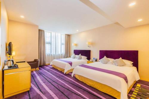 a hotel room with two beds and a television at The Bauhinia in Shenzhen