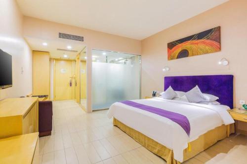 a bedroom with a large bed and a tv at The Bauhinia in Shenzhen