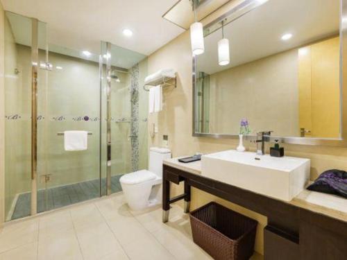 a bathroom with a sink and a toilet and a shower at The Bauhinia in Shenzhen