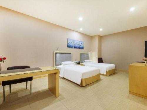 a hotel room with two beds and a desk at The Bauhinia in Shenzhen
