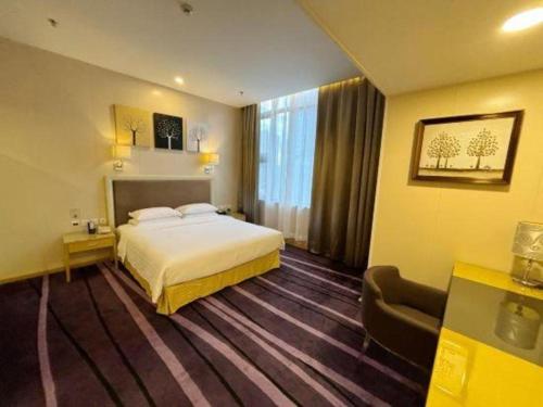 a hotel room with a bed and a chair at The Bauhinia in Shenzhen
