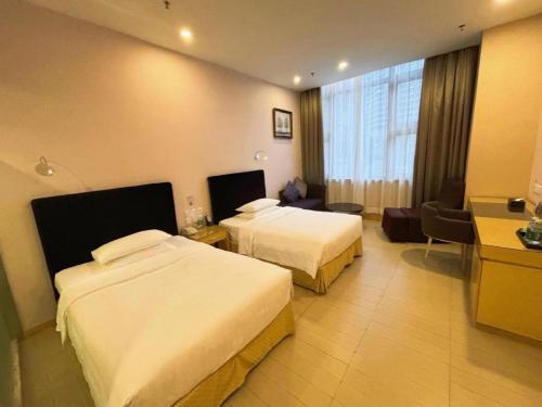a hotel room with two beds and a desk at The Bauhinia in Shenzhen