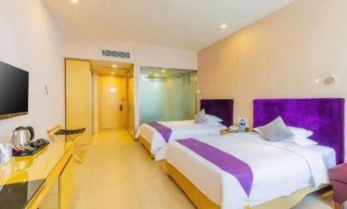 a hotel room with two beds and a tv at The Bauhinia in Shenzhen