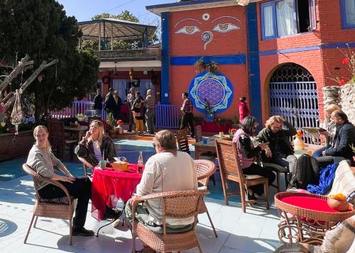 a group of people sitting around a table in a patio at Joy Source Resort in Kathmandu