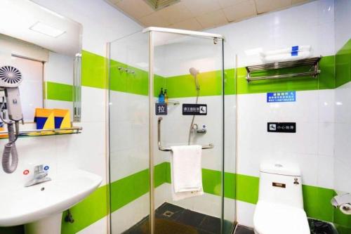 a green and white bathroom with a sink and a shower at 7 Days Inn Xi'an Railway Station in Xi'an
