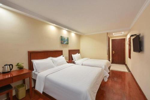 a hotel room with two beds and a television at GreenTree Inn Nanjing Forestry University National Exhibition Center Express Hotel in Nanjing