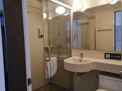 ein Badezimmer mit Waschbecken, Spiegel und Toilette in der Unterkunft 7 Days Inn Tianjin Changhong Park Metro Station in Tianjin