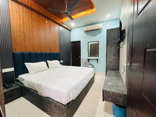 a bedroom with a white bed and blue walls at Hotel Airport Suites Suitable for Hourly Bookings in Lucknow