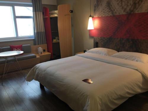 a hotel room with a large bed and a couch at ibis Shenyang north station in Shenyang