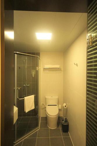 a bathroom with a toilet and a glass shower at ibis Shenyang north station in Shenyang