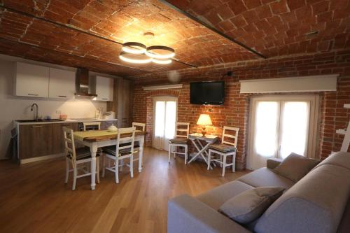 Una sala de estar con un sofá y una pared de ladrillos. en Alba sui Tetti apartment, en Alba