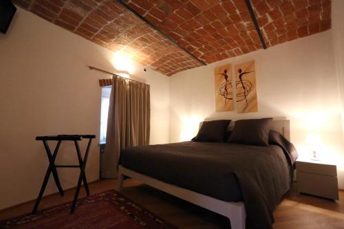 1 dormitorio con 1 cama con techo de ladrillo en Alba sui Tetti apartment, en Alba