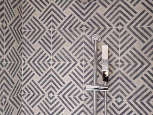 a wall mural with a geometric design in a bathroom at Jinjiang Metropolo Shanghai Xujiahui Nanhuating Hotel in Shanghai