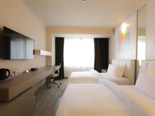 a hotel room with three beds and a desk at Jinjiang Metropolo Shanghai Xujiahui Nanhuating Hotel in Shanghai