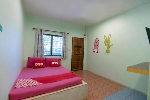 a bedroom with a large bed with pink pillows at OYO 931 Sor Chareanpanit in Pattaya Central