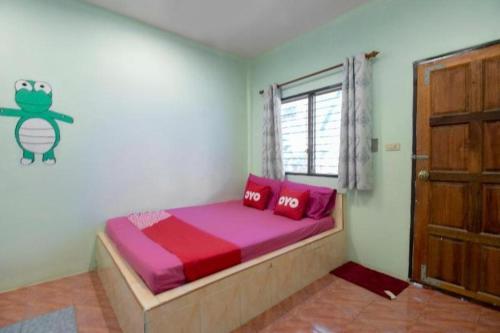 a bedroom with a bed with pink sheets and a window at OYO 931 Sor Chareanpanit in Pattaya Central