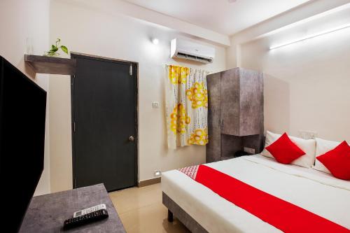 a bedroom with a bed and a black door and a table at Hotel O D' Jade in Hyderabad