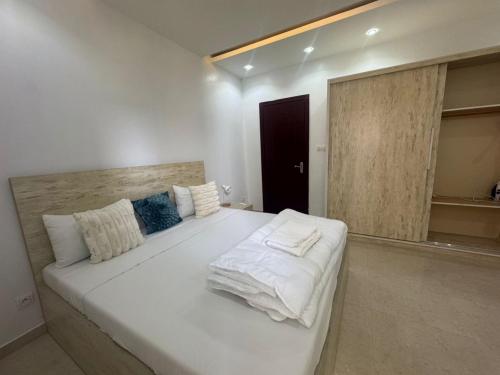 a bedroom with a large white bed with white sheets at Résidence FARASELAA in Dakar