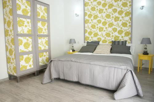 1 dormitorio con 1 cama y una pared con flores en Alojamiento EntreHoces, en Cuenca