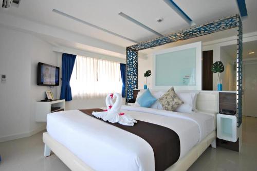 een slaapkamer met een groot wit bed met een zwaan erop bij Hinn - Namm Hotel in Hua Hin
