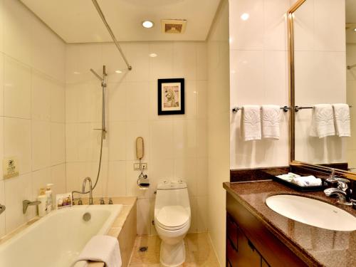 a bathroom with a tub and a toilet and a sink at Yiwu Yimei Plaza Hotel in Yiwu