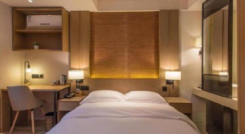 a bedroom with a bed and a desk and a window at V8 Ziyuangang Hotel in Guangzhou
