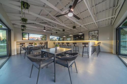 a dining room with tables and chairs and windows at Room 4 - LEO Sky Guest House in Simondium
