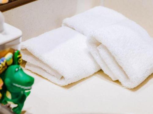 a stack of white towels on a counter with a toy at Hangzhou The First World Hotel in Hangzhou