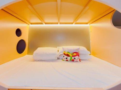 a white bed with two stuffed animals sitting on it at Hangzhou The First World Hotel in Hangzhou
