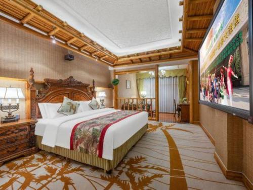 a bedroom with a large bed and a flat screen tv at Hangzhou The First World Hotel in Hangzhou