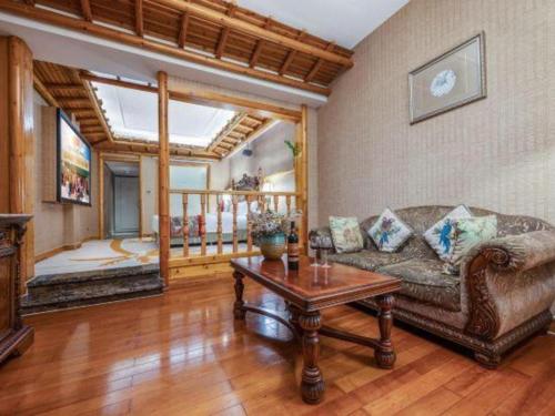 a living room with a couch and a table at Hangzhou The First World Hotel in Hangzhou
