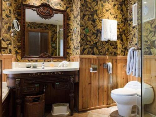 a bathroom with a toilet and a sink and a mirror at Hangzhou The First World Hotel in Hangzhou